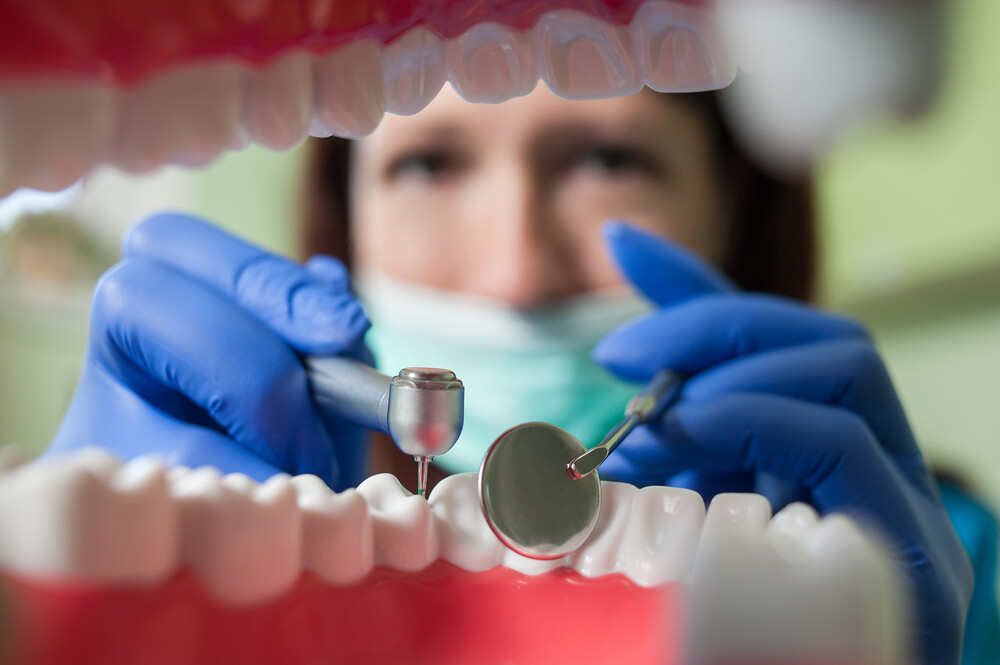 Close-up of dentist drilling teeth. View of a doctor from the inside of mouth. Focus on medical tools