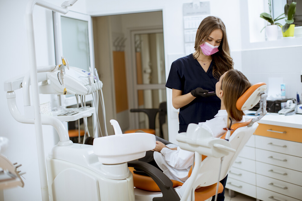 Pretty young woman at oral checkup at the dentist office